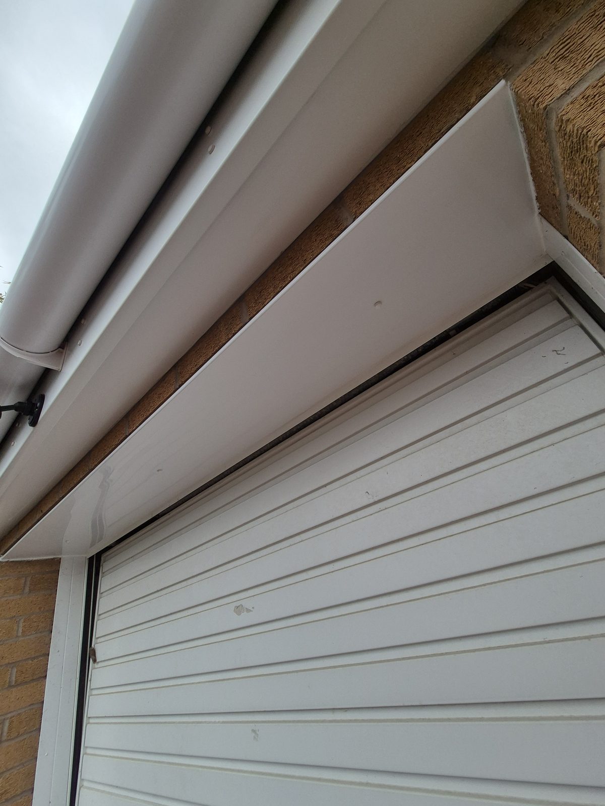 Newly fitted white UPVC fascia and gutter above a garage