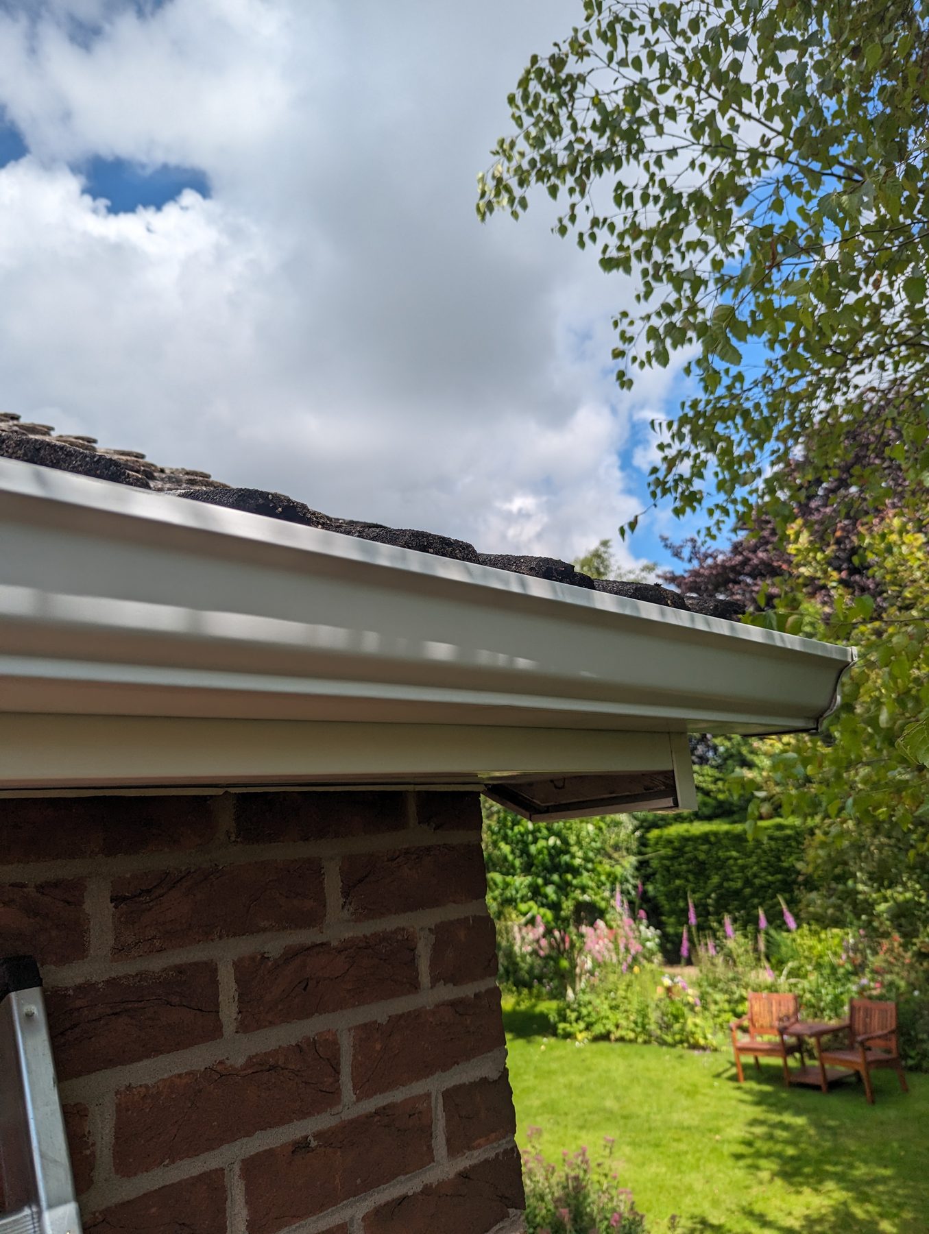 Crisp white UPVC gutter and fascia freshly fitted on a red-brick home